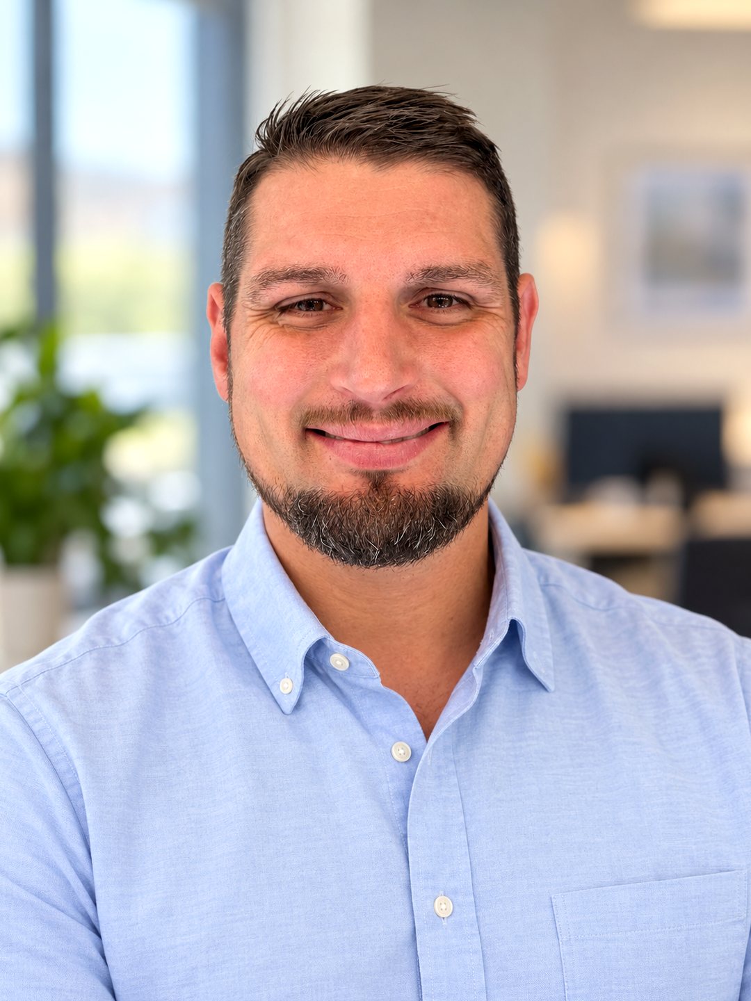 Michael Peluso, founder of True Living, smiling in a light blue shirt
