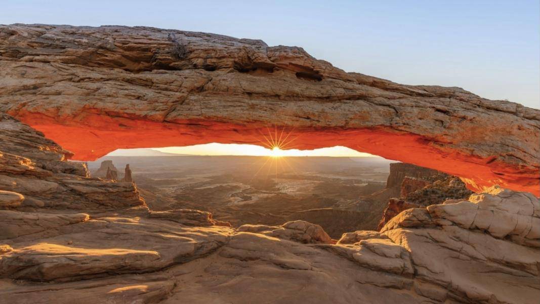 Sunrise glowing under Mesa Arch in Canyonlands