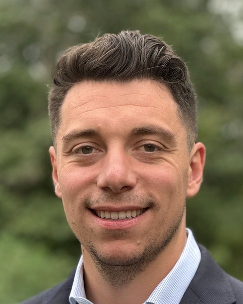 Alessandro Amato, Business Development Manager at True Living, outdoors in a suit jacket