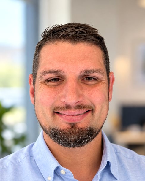 Michael Peluso, founder of True Living, smiling in a light blue shirt