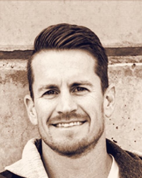 Robbie Law, smiling in front of a concrete wall